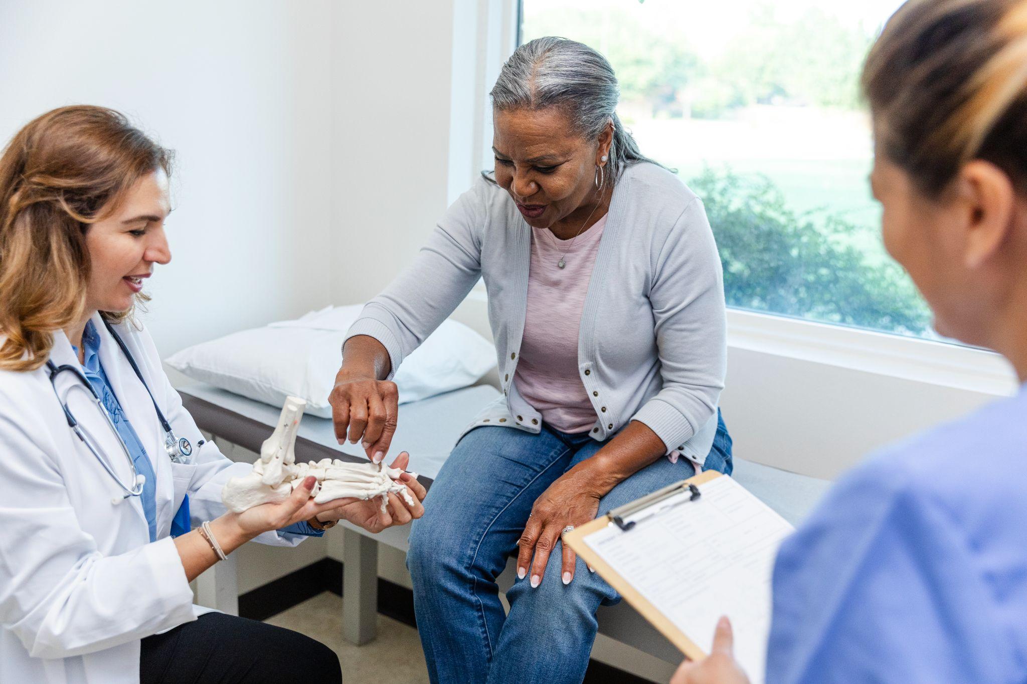 An older woman visits the doctor regarding her bone health.